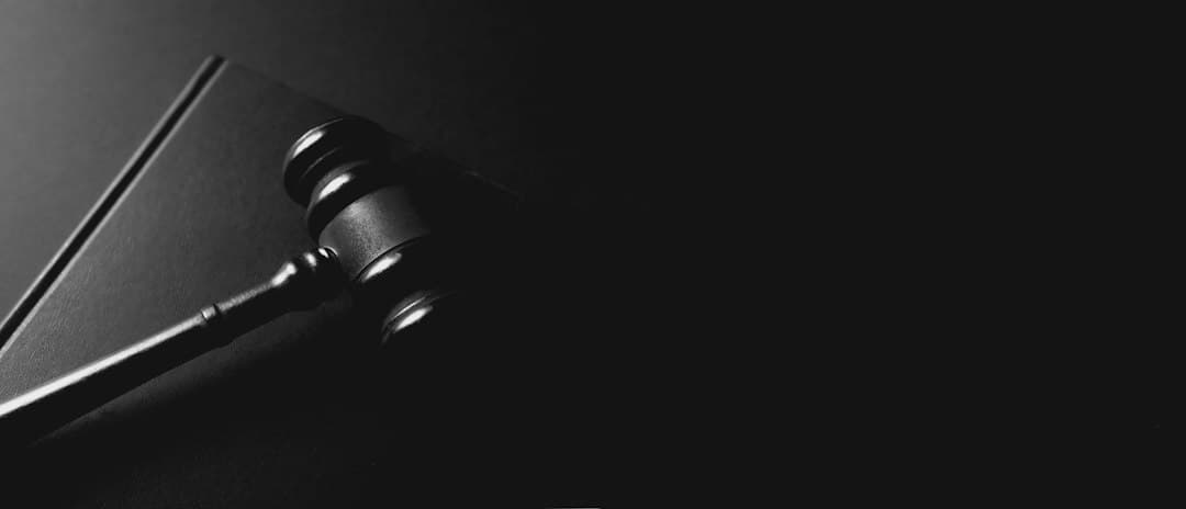 Marteau de juge posé sur un bureau à côté de livres de droit